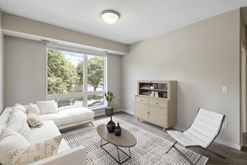 Minneapolis apartment for rent - an open living room with white furniture and a large window