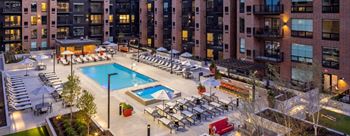 An overhead view of a swimming pool in front of an apartment building