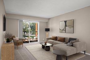 Plymouth apartment for rent - A living room with a grey couch, a wooden side table, and a large window.