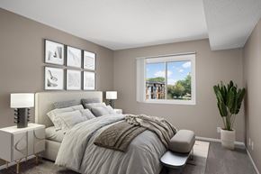 Plymouth apartment for rent - A bedroom with a large bed and a window overlooking a building.