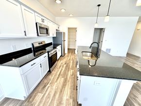 Lafayette triplex for rent - A kitchen with white cabinets and black countertops.at Concord Crossing, Lafayette, IN  