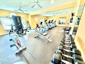 Lafayette triplex for rent - A gym with a variety of equipment including treadmills, stationary bikes, and dumbbells.