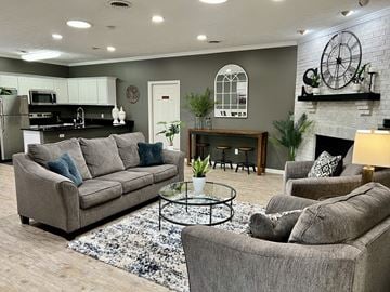 Lafayette triplex for rent - A living room with grey couches and a fireplace.