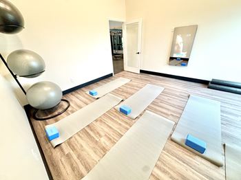 A yoga studio with mats and blocks on the floor.