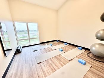A room with yoga mats and blocks on the floor.