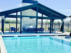 Lafayette triplex for rent - A pool with a glass divider and a black fence.