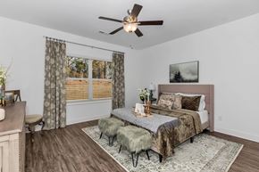 Madison triplex for rent - A bedroom with a bed, a bench, and a ceiling fan.