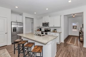 Madison triplex for rent - A kitchen with white cabinets and a granite countertop.
