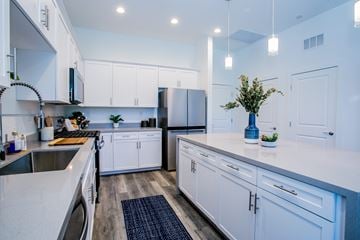 Las Vegas townhouse for rent - A modern kitchen with white cabinets and a dark countertop.