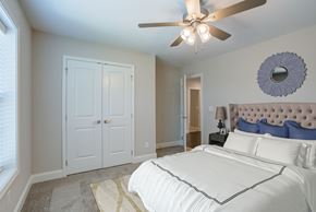 Knoxville townhouse for rent - A bedroom with a white bed and a ceiling fan.
