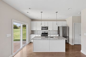 Knoxville townhouse for rent - A kitchen with white cabinets and a marble countertop.