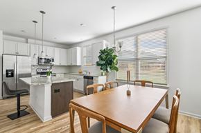 Stockbridge townhouse for rent - a kitchen with white cabinets and a wooden table