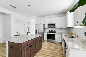 Stockbridge townhouse for rent - a large kitchen with marble counter tops and white cabinets