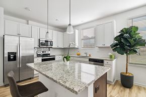 Stockbridge townhouse for rent - a kitchen with white cabinets and a marble counter top