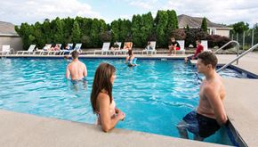 Greenfield apartment for rent - a group of people playing in a swimming pool