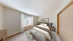 Hales Corners townhouse for rent - A bedroom with a large bed and a window with curtains.