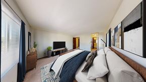 West Allis apartment for rent - A bedroom with a large bed and a television.