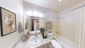 West Allis apartment for rent - A bathroom with a white tub, sink, and toilet.