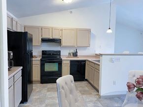 Greenfield apartment for rent - a kitchen with a black stove and a black refrigerator