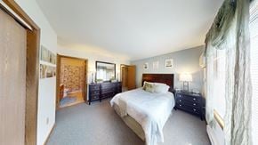 Pewaukee apartment for rent - A bedroom with a large bed and a window with curtains.