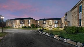 Greendale apartment for rent - a row of brick apartment buildings with green grass and a road