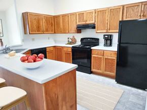 New Berlin apartment for rent - a kitchen with black appliances and wooden cabinets
