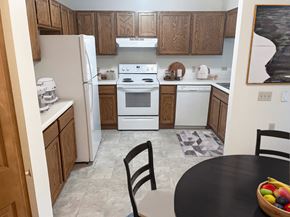 Greenfield apartment for rent - a kitchen with white appliances and wooden cabinets and a black table
