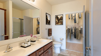Bathroom with a large mirror and a toilet next to a walk in shower