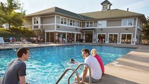 Brookfield apartment for rent - a group of people sitting at a pool with a building in the background