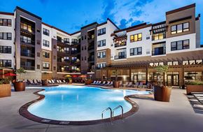 Brookfield apartment for rent - A large swimming pool is surrounded by a patio area with chairs and umbrellas.