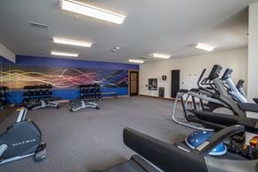 Menomonee Falls apartment for rent - A gym with a blue wall and a row of treadmills.