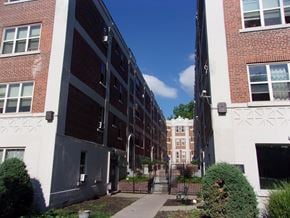 Buffalo apartment for rent - A long building with a lot of windows and bushes in front.