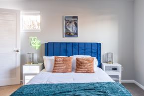Canandaigua apartment for rent - A bedroom with a large bed and a blue headboard at Centerpointe Apartments, Canandaigua, NY