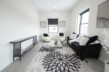 Buffalo apartment for rent - A black and white living room with a rug and a couch.