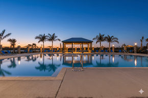 Cocoa apartment for rent - A gazebo is situated in the middle of a pool with palm trees in the background.