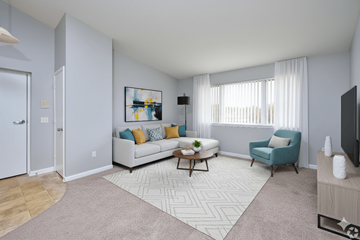 Canandaigua apartment for rent - A living room with a white couch, a coffee table, a blue armchair, and a painting on the wall.