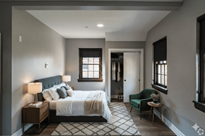 Buffalo apartment for rent - A bedroom with a large bed and a green chair.