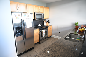 Buffalo apartment for rent - A kitchen with a refrigerator, microwave, oven, sink and a potted plant.