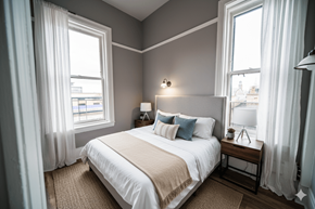 Buffalo apartment for rent - A bedroom with a large bed and two windows.