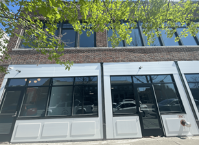 Buffalo apartment for rent - A building with a brick facade and large windows with a tree branch hanging over the windows.