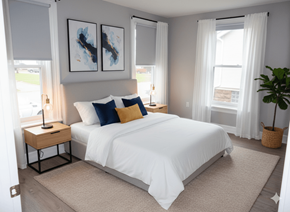 Buffalo apartment for rent - A bedroom with a white bed and a white nightstand with a lamp.