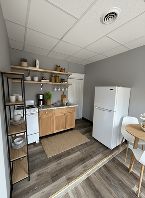 Buffalo apartment for rent - A kitchen with a white refrigerator, wooden floors, and a white ceiling.