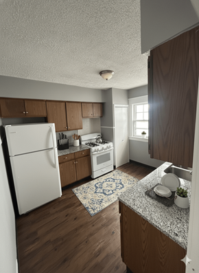 North Buffalo apartment for rent - A kitchen with a white refrigerator and wooden cabinets.
