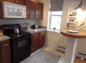 Buffalo apartment for rent - A kitchen with a black stove and wooden cabinets.