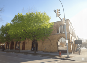 Buffalo apartment for rent - A tree with green leaves is in front of a building with a brick facade.