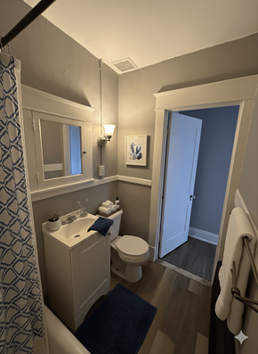 Buffalo apartment for rent - A bathroom with a toilet, sink, and mirror.