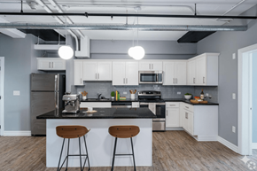 Buffalo apartment for rent - A kitchen with white cabinets and a black countertop.