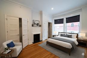 Buffalo apartment for rent - A bedroom with a large bed and a fireplace.