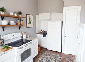 Buffalo apartment for rent - A kitchen with white appliances and a rug on the floor.