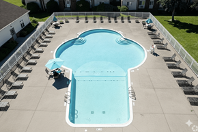 Fairport apartment for rent - A large outdoor swimming pool surrounded by lounge chairs.at Highview Manor Apartments, Fairport, 14450